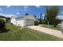View of a single-story home with a one-car garage, driveway, and landscaping at 17930 Se 83Rd Melody Ave, The Villages, FL 32162