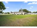 Spacious backyard with a well-maintained lawn and a screened lanai at the back of the house at 17985 Se 102Nd Ct, Summerfield, FL 34491