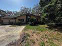 Well-maintained ranch-style home with an attached two-car garage, lush landscaping and mature trees at 18130 Keene Rd, Altoona, FL 32702