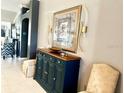 Stylish foyer with a beautiful credenza, decorative sconces, seating, and arched entry at 1875 Oxford Ln, The Villages, FL 32162