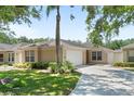 Charming one-story home with lush green lawn and mature landscaping, featuring a two-car garage and welcoming entrance at 2012 Braxton St, Clermont, FL 34711