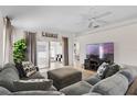 Inviting living room featuring a comfortable sectional sofa, modern entertainment center, and access to outdoor space at 2012 Braxton St, Clermont, FL 34711