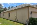 This angle shows the side yard of the home, highlighting the exterior paint and landscaping at 2129 Amor Way, Leesburg, FL 34748