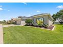 This house boasts a well-manicured lawn and an inviting exterior enhanced by lush landscaping at 25524 Maurepas Ln, Leesburg, FL 34748