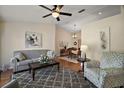 Comfortable living space with hardwood floors, ceiling fan, and an adjacent dining area at 27022 Racquet Cir, Leesburg, FL 34748