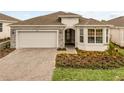 Charming single-story home featuring a neatly landscaped front yard and a two-car garage at 2786 Top Hill Ct, Minneola, FL 34715
