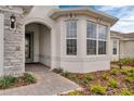Close up of a charming home's front entrance showing a decorative glass door and neatly manicured landscaping at 2786 Top Hill Ct, Minneola, FL 34715