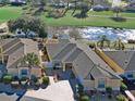 Stunning aerial view of a one-story home near a golf course, featuring a well-manicured lawn and lush landscaping at 3325 Archer Ave, The Villages, FL 32162