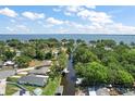 Aerial view of a neighborhood canal leading to a large lake with lush greenery, and beautiful blue skies at 33635 Jeffery Ct, Leesburg, FL 34788