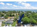 Aerial view of neighborhood with canal leading to a large lake, lush greenery and the blue arrow points to a boathouse at 33635 Jeffery Ct, Leesburg, FL 34788