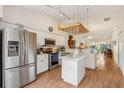 Open concept kitchen featuring stainless steel appliances, island and breakfast bar at 340 Juniper Way, Tavares, FL 32778