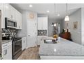 Modern kitchen featuring stainless steel appliances, granite countertops, and sleek white cabinetry at 37045 Scenic Ridge Dr, Grand Island, FL 32735