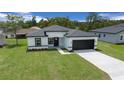 Charming single-story home showcasing a well-maintained lawn and a modern black-and-white color scheme at 3978 Sw 151St St, Ocala, FL 34473