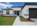 Beautiful home exterior featuring a well-kept lawn and modern black and white accents on the facade at 3978 Sw 151St St, Ocala, FL 34473