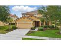 Charming two-story home with manicured lawn, beautiful landscaping, and neutral color palette at 4147 Oaktree Dr, Davenport, FL 33837