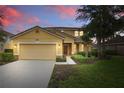 Two-story home with neutral color palette and well-manicured front lawn at 4147 Oaktree Dr, Davenport, FL 33837