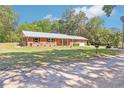 Beautiful single-story brick home with a well-manicured front lawn and a metal roof at 42116 E Lakeview Dr, Altoona, FL 32702