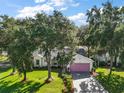 Aerial view of a quaint, single-story home showcasing its lush landscaping, large trees and unique driveway design at 4349 River Ridge Dr, Leesburg, FL 34748