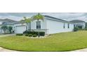 Beautiful property showcases lush green grass, stone accents, and well-placed palm trees in a serene setting at 496 Brunswick Dr, Davenport, FL 33837