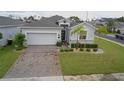 Inviting home with a well-kept lawn, stylish stone accents, and a convenient two-car garage at 496 Brunswick Dr, Davenport, FL 33837