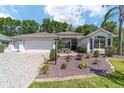 Lovely single-story home with an attached garage, manicured landscaping, and a charming walkway to the front door at 529 Cokesbury Dr, The Villages, FL 32162
