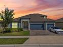 Beautiful single Gathering home with a three car garage, landscaped yard and warm sunset at 533 Avila Pl, Howey In The Hills, FL 34737