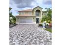 Two-story home features manicured landscaping, an arched entryway, and a large garage at 54 Andora Ct, Kissimmee, FL 34758