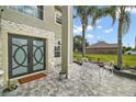 Inviting entryway with stone tile, wrought iron seating, and decorative front door at 54 Andora Ct, Kissimmee, FL 34758