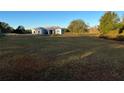 A spacious home exterior is surrounded by a lush green lawn and mature trees at 6619 Ona Ct, Clermont, FL 34714