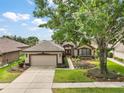 Charming single-story home featuring manicured landscaping and a welcoming red double-door entrance at 7034 Pine Hollow Dr, Mount Dora, FL 32757