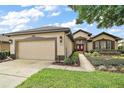 Charming home featuring manicured landscaping, a two-car garage, and a welcoming red double-door entrance at 7034 Pine Hollow Dr, Mount Dora, FL 32757