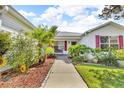Inviting front entrance with lush landscaping and a cozy bench for enjoying the serene neighborhood at 767 Barbados Pl, The Villages, FL 32162