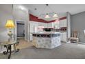Well-designed kitchen featuring a functional island, ample counter space, and sleek white cabinetry at 767 Barbados Pl, The Villages, FL 32162