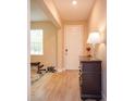 Bright foyer with wood-look tile floors, white door, and a stylish console table with a lamp at 769 Daybreak Pl, Longwood, FL 32750