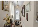 Warm, inviting hallway featuring decorative artwork, neutral paint, and an elegant overhead light fixture at 9089 Saint Andrews Way, Mount Dora, FL 32757