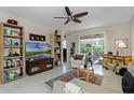 Bright and spacious living room featuring tile floors, built-in shelving, ceiling fan and ample natural light at 9089 Saint Andrews Way, Mount Dora, FL 32757