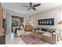 Cozy living room with neutral paint, ceiling fan, and tile flooring, connecting to an outdoor space at 9089 Saint Andrews Way, Mount Dora, FL 32757