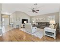 Cozy living room featuring hardwood floors, neutral paint, vaulted ceilings, and plush seating at 973 Baisley Trl, The Villages, FL 32162