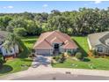 Beautiful one-story home featuring a brick paved driveway, well maintained landscaping, and a neutral color palette at 10069 Lake Miona Way, Oxford, FL 34484