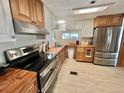Bright kitchen featuring stainless steel appliances, stylish range hood and wooden countertops at 104 Valencia Cv, Leesburg, FL 34748