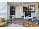 Cozy front porch featuring rocking chairs, decorative plants, and a welcoming atmosphere at 106 Baytree Blvd, Tavares, FL 32778