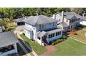 A view of a charming two-story home with mature landscaping and a brick walkway at 1109 W Line St, Leesburg, FL 34748