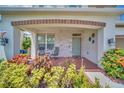 Inviting front porch with stone accents, stylish lighting, and comfortable seating area surrounded by vibrant plants at 1281 Gatewood Ave, Minneola, FL 34715