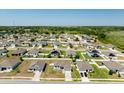 An aerial view of a home in a neighborhood with well-maintained lawns and many other houses at 15287 Aquarius Way, Mascotte, FL 34753