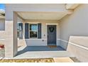 Inviting front porch with a gray front door with a wreath and blue shutters at 15287 Aquarius Way, Mascotte, FL 34753