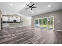 Open-concept living room with sleek floors, vaulted ceiling, and sliding glass doors to the outdoor space at 155 W C-466, Lot # 1 W C 466, Oxford, FL 34484