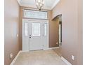 Welcoming foyer with tile flooring, decorative chandelier, and views into the home at 17427 Se 72Nd Overbrook Ct, The Villages, FL 32162