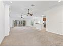 Spacious living area with neutral carpet, ceiling fans, and access to the lanai at 17427 Se 72Nd Overbrook Ct, The Villages, FL 32162