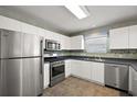 Modern kitchen with stainless steel appliances and white cabinets at 17800 Se 91St Gaylark Ave, The Villages, FL 32162