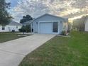 Charming single-story home featuring a well-manicured lawn, driveway, and attached garage at 1812 Sanibel Ct, The Villages, FL 32162
